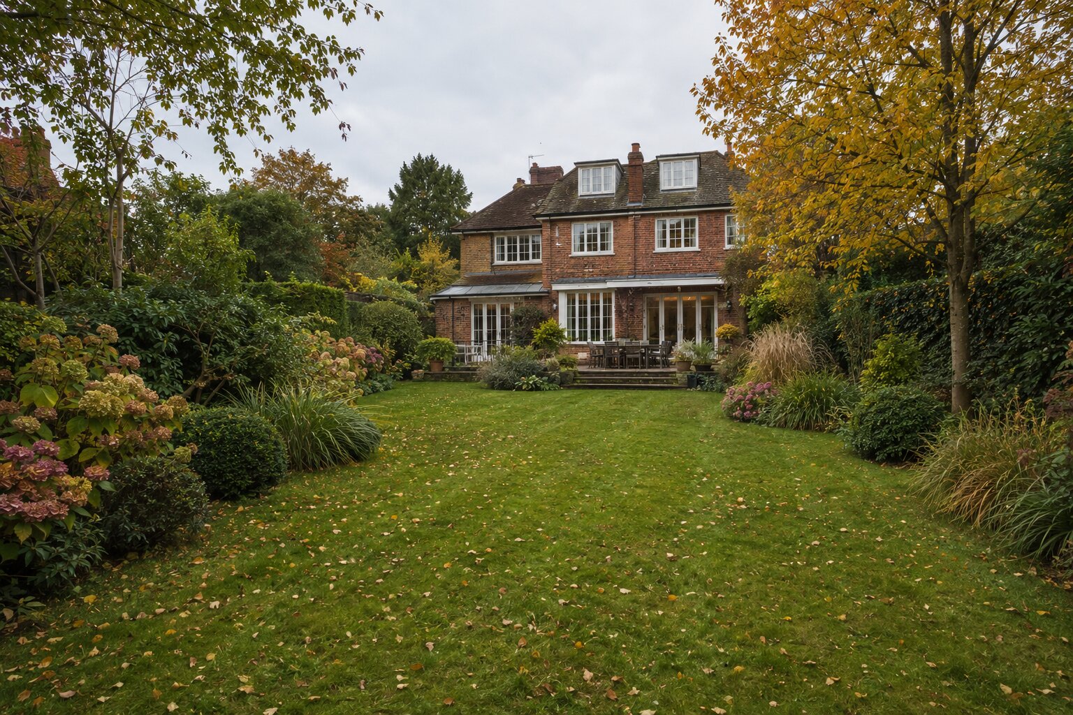 Detailed rear garden before Signature Care maintenance, with tired borders, soft edges and overgrown hedging.